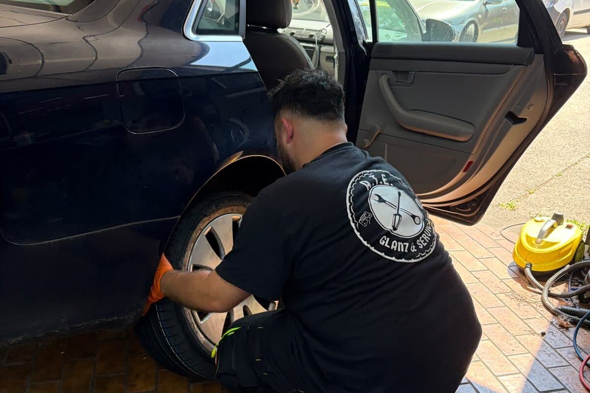 Mitarbeiter von A.T.E Glanz & Service beim Radwechsel an einem Fahrzeug