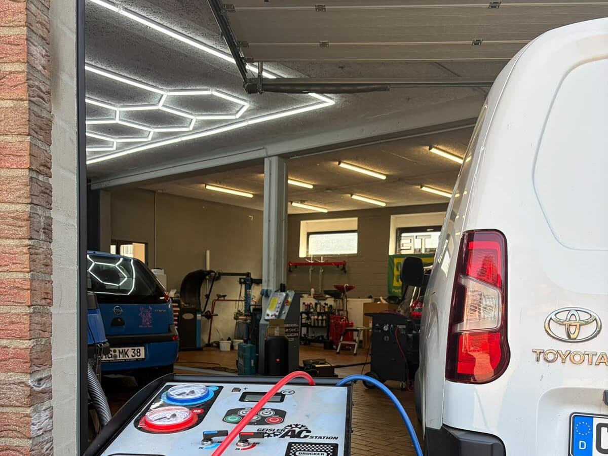 Geöffnete Garageneinfahrt zur Werkstatt von A.T.E Glanz & Service mit Blick in die Halle