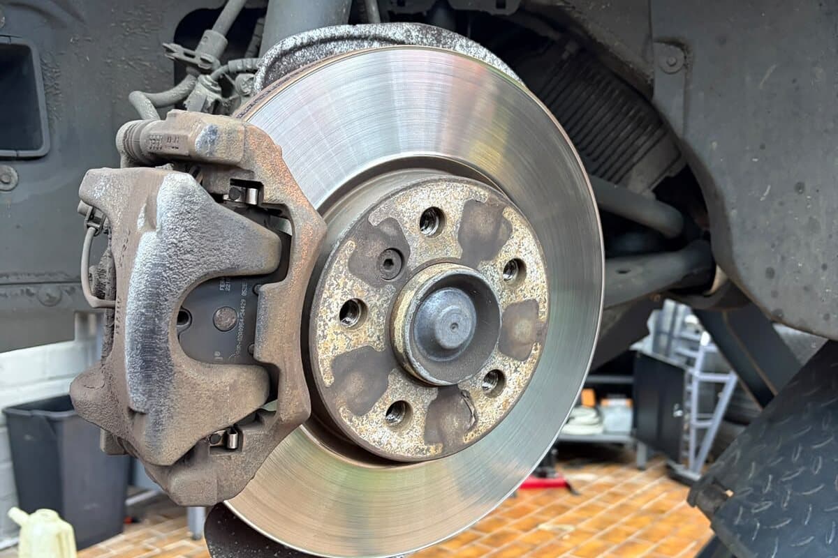 Freigelegte Bremsscheibe mit Bremssattel am abgenommenen Rad
